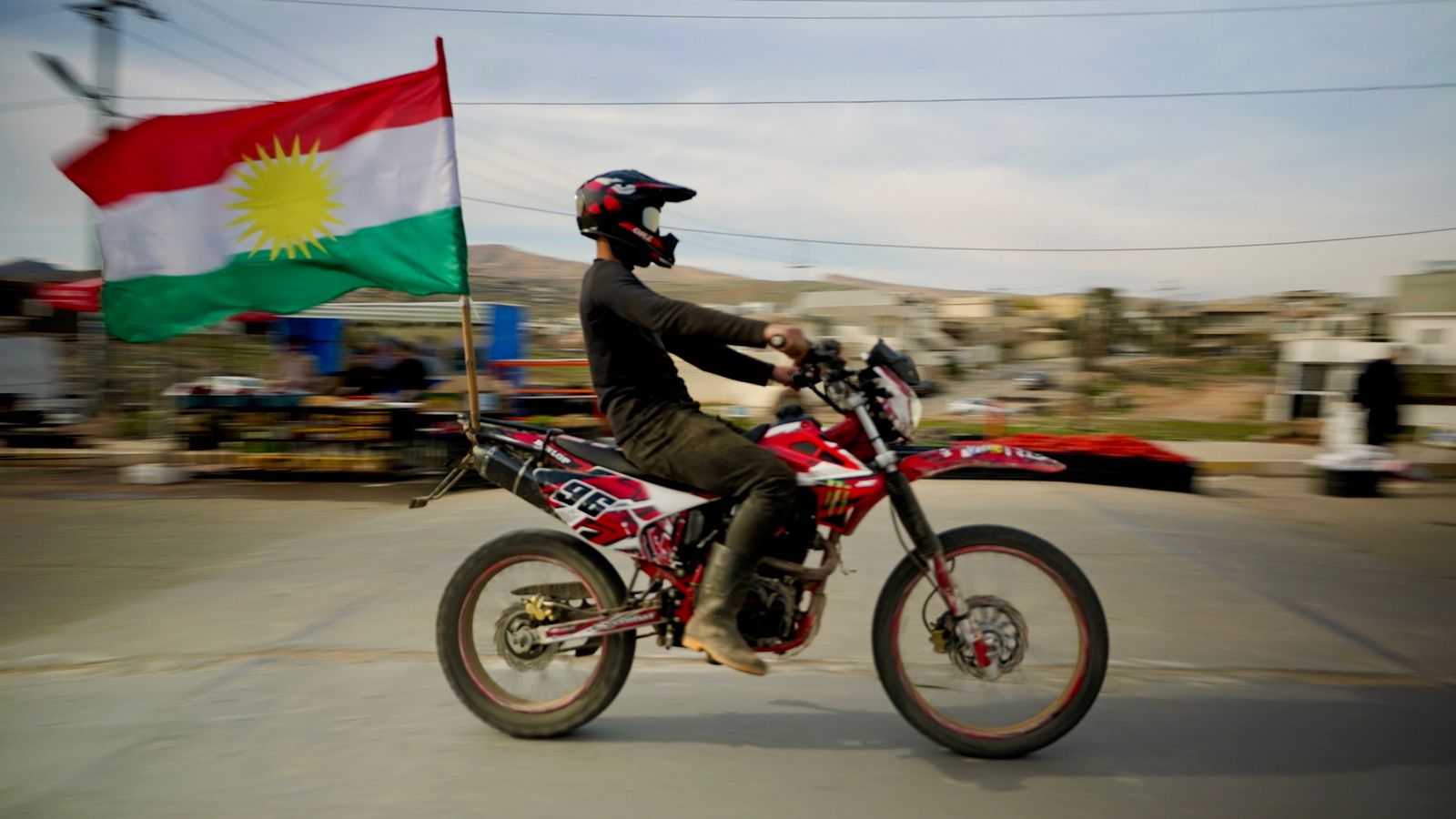A biker proudly displays a Kurdistan flag