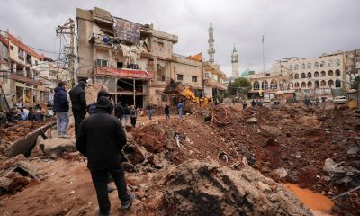 People inspect the damage where Israel's military carried out an airborne operation that dropped troops in Nabi Chit. Pic: Reuters