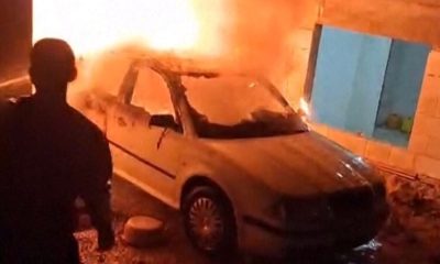 A man tries to put out a car fire in Deir al-Hatab, in the West Bank. Pic: AP
