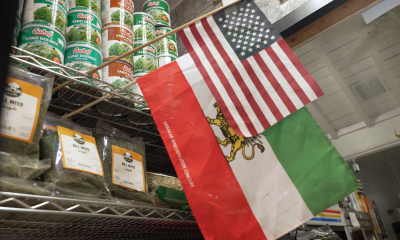 Iran's pre-Islamic Revolution flag alongside the US flag at Mr Saddigh's shop