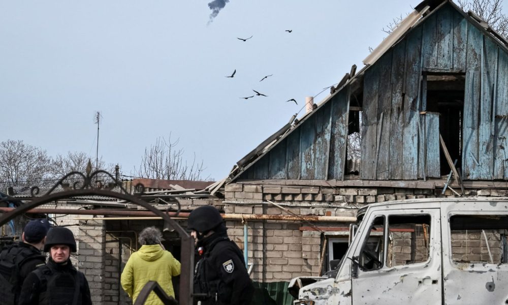 Police officers work at the site of a building hit by a Russian drone strike. Pic: Reuters