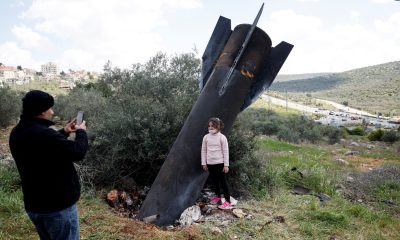 A girl stands next to the remnants of a missile in Kifl Haris village in the West Bank. Pic: Reuters