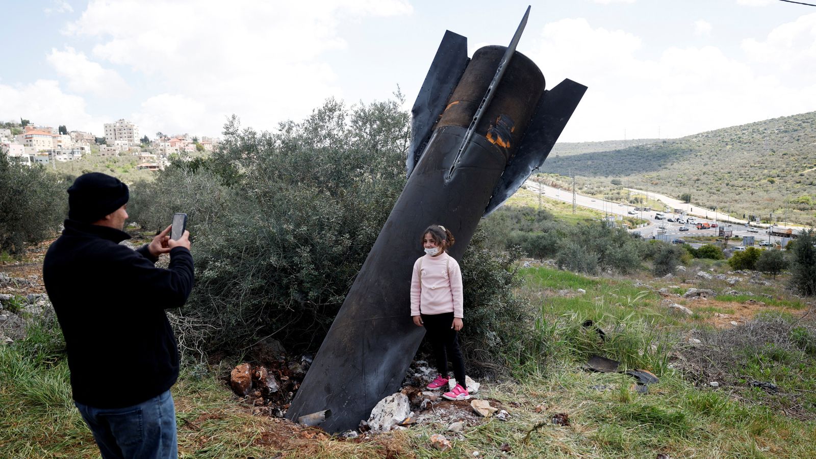 A girl stands next to the remnants of a missile in Kifl Haris village in the West Bank. Pic: Reuters