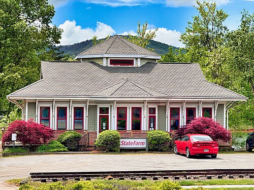 A State Farm Insurance office occupies a classic railroad depot