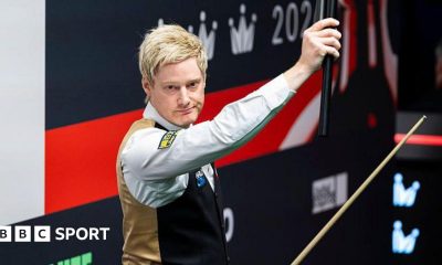 Neil Robertson holds his cue extension aloft