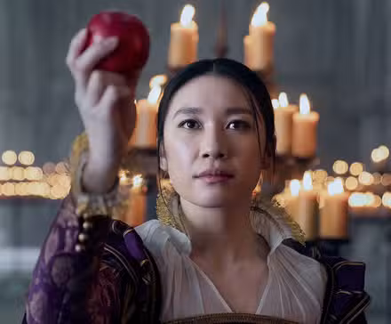 Jess Hong as Jin Cheng holding up an apple in a candlelit church in episode 103 of '3 Body Problem.'