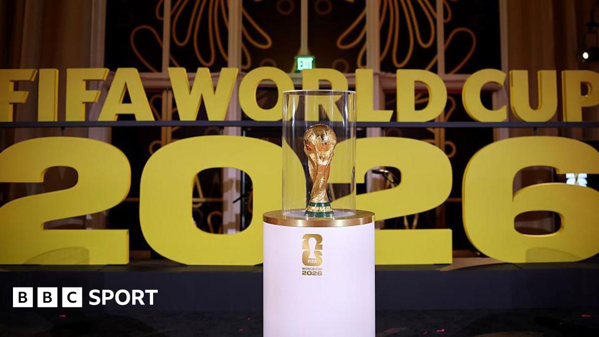 The World Cup on display on a white stand prior to the draw in December in Washington with Fifa World Cup 2026 in big gold letters in the background.