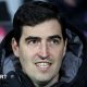 Bournemouth manager Andoni Iraola smiles as he watches a match