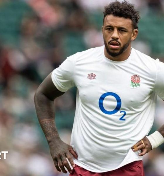 Courtney Lawes standing on the pitch with an England shirt on and his hands on his hips