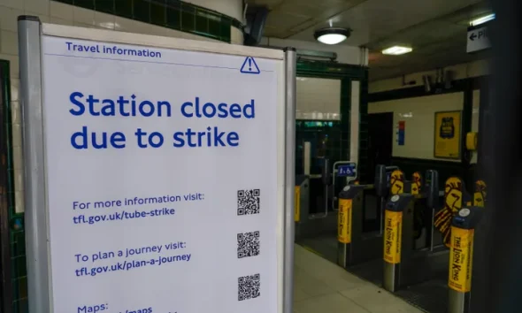 A sign reading 'Station closed due to strike' is placed inside Covent Garden Underground station, in London, Tuesday, June 21, 2022. Tens of thousands of railway workers walked off the job in Britain on Tuesday, bringing the train network to a crawl in the country's biggest transit strike for three decades. (AP Photo/Alberto Pezzali)