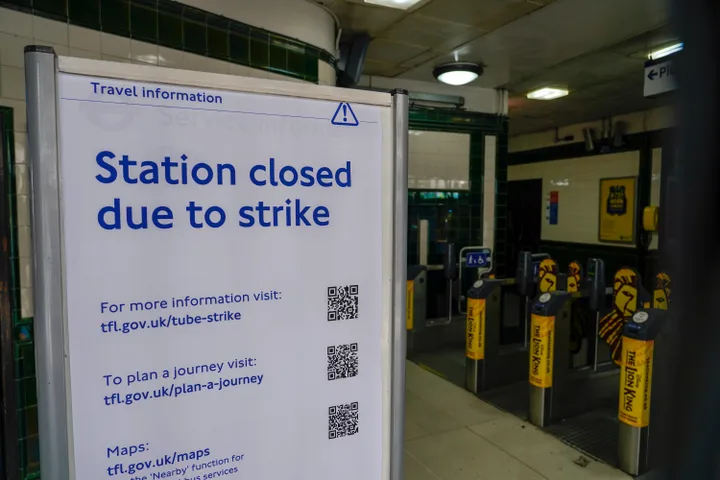 A sign reading 'Station closed due to strike' is placed inside Covent Garden Underground station, in London, Tuesday, June 21, 2022. Tens of thousands of railway workers walked off the job in Britain on Tuesday, bringing the train network to a crawl in the country's biggest transit strike for three decades. (AP Photo/Alberto Pezzali)