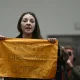 A demonstrator gets up and shows a banner reading "Youth Deserve Better" during the launching speech of Britain's main opposition Labour Party election manifesto booklet, in Manchester, on June 13, 2024