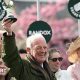 Willie Mullins smiling and holding a trophy in the air