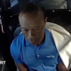 Tiger Woods sits in the back of a police car after being arrested