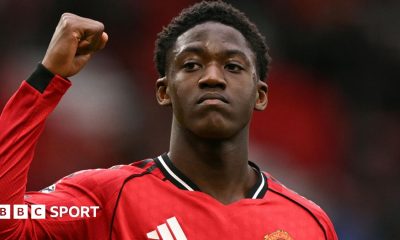 Kobbie Mainoo gestures to fans