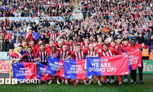 The Lincoln City squad celebrating their promotion infront of their visiting supporters at Reading's Select Car Leasing Stadium.
