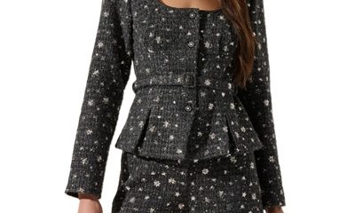 A woman wearing a gray sequined jacket and shorts set