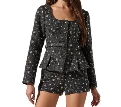 A woman wearing a gray sequined jacket and shorts set