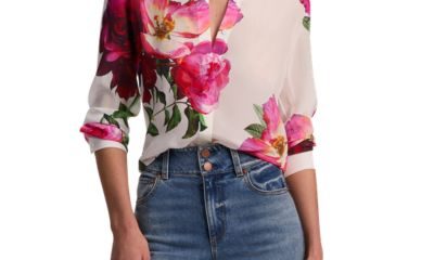 A woman wearing a floral blouse and blue jeans