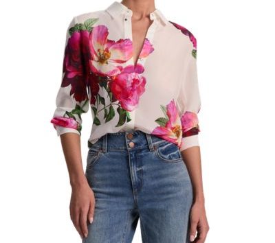 A woman wearing a floral blouse and blue jeans