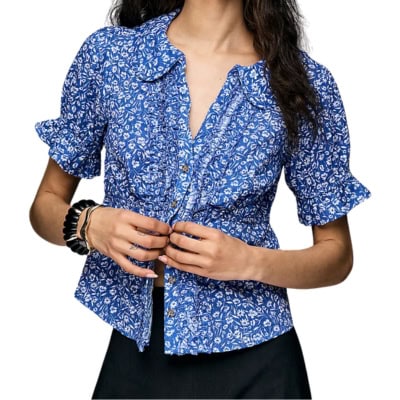 A woman wearing a blue-and-white floral blouse and black pants