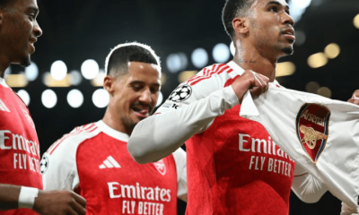 Arsenal players celebrate their 4-0 win over Atletico Madrid in October 2025. One players holds a t-shirt with the Arsenal emblem printed on it