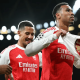 Arsenal players celebrate their 4-0 win over Atletico Madrid in October 2025. One players holds a t-shirt with the Arsenal emblem printed on it
