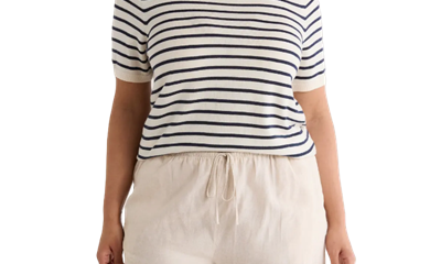 A woman wearing ivory shorts and ivory-and-navy striped top