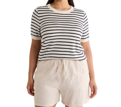 A woman wearing ivory shorts and ivory-and-navy striped top