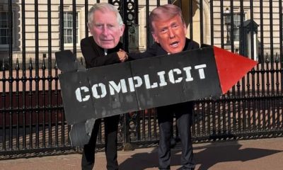 Protesters against Charles's state visit to Trump wear Charles and Trump masks and hold a prop missile saying COMPLICIT in front of Buckingham Palace