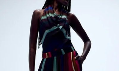 A woman wearing a multicolored striped top and coordinating balloon pants