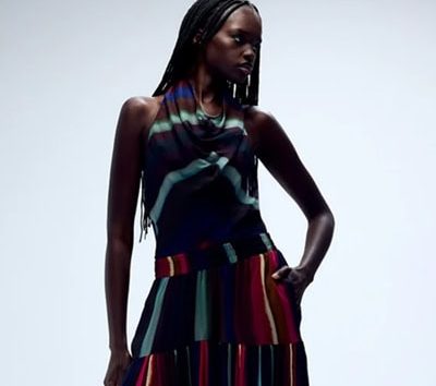 A woman wearing a multicolored striped top and coordinating balloon pants