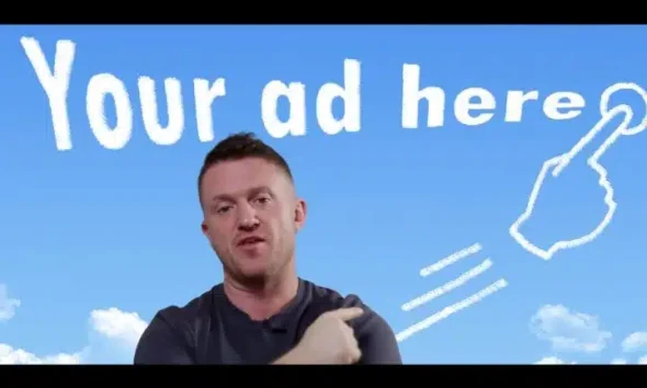 Tommy Robinson with a sign behind him which reads 'your ad here'