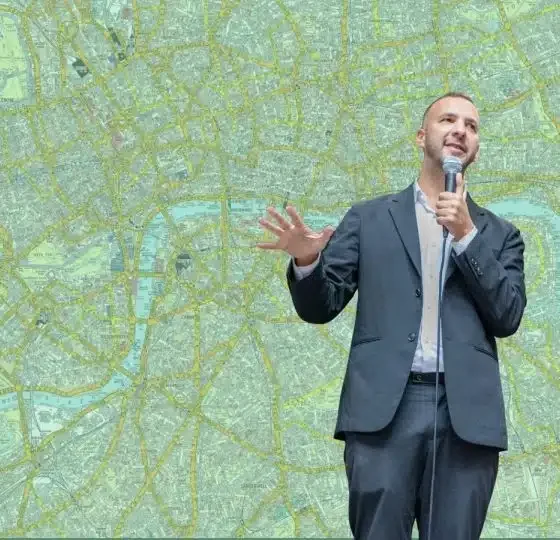 Zack Polanski in front of a green map of London