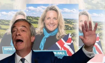 Nigel Farage in front of a candidate's flyer Reform