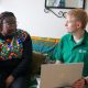 Green Doctors project manager, Daniel Brittle, holding a laptop, speaking to service user Pearl.