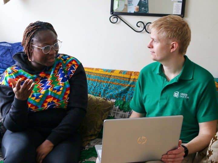Green Doctors project manager, Daniel Brittle, holding a laptop, speaking to service user Pearl.