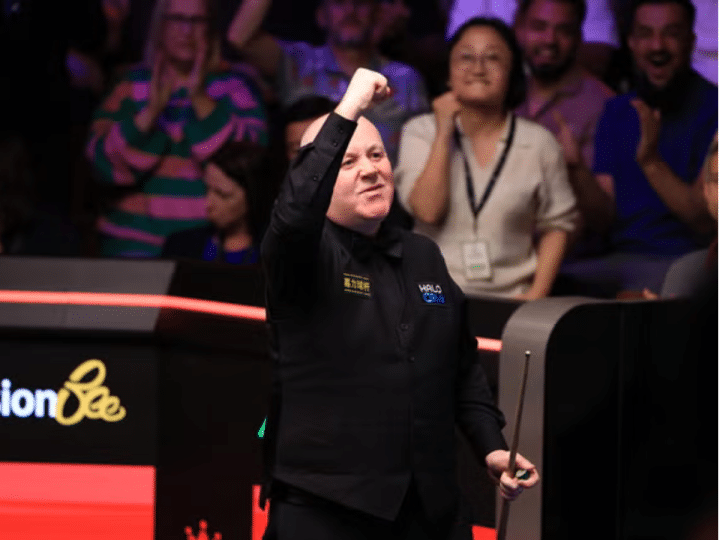 John Higgins celebrates victory over Ronnie O'Sullivan