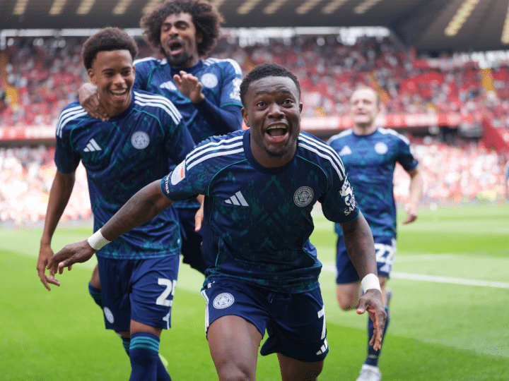Abdul Fatawu celebrates with his Leicester teammates after scoring the winner against Charlton in August 2025. His mouth is open as he runs towards the photographer and his two teammates smile and laugh behind him