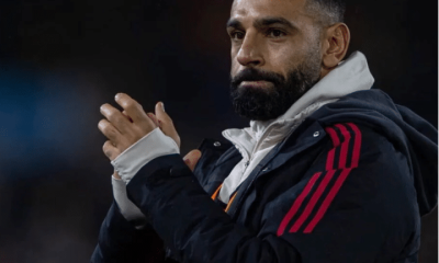 Liverpool player, Mo Salah, claps his hands together and looks somewhat morose looking on in the distance