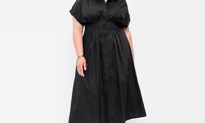 A woman wearing a black midi shirtdress and black sandals