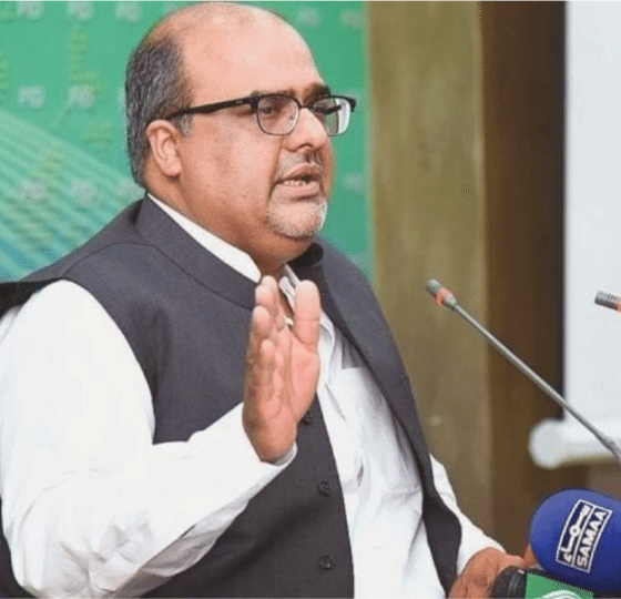 Shazad Akbar, a Pakistani dissident, speaks in front of small news microphones