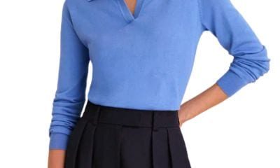 A woman wearing a blue polo sweater and black pants