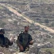 Israeli occupation soldiers photographed against a backdrop of rocky hills in April 2026