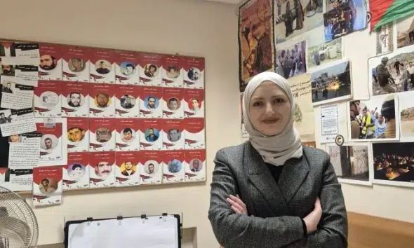 Sundos Hammad stands with her hands folded and smiling