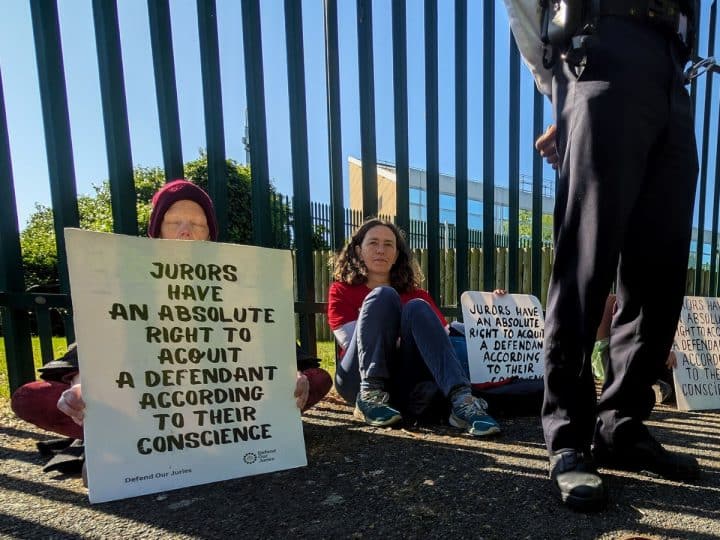 Protesters hold placards outside Woolwich Crown Court