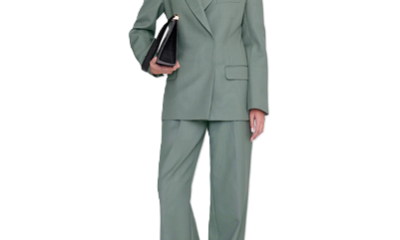 woman wears sage green suit and carries an executive clutch