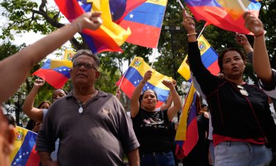People gather at a government-organized event to watch former President Nicolas Maduro and first lady Cilia Flores appear in a New York court on a screen in Caracas, Venezuela, on March 26, 2026.