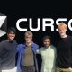 Four people smiling in front of the Cursor AI logo on a black background.