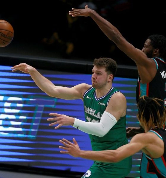 Dallas Mavericks star Luka Doncic passes the ball against Brandon Clarke, 15, and Justise Winslow ,7, of the Memphis Grizzlies in the second half at American Airlines Center
